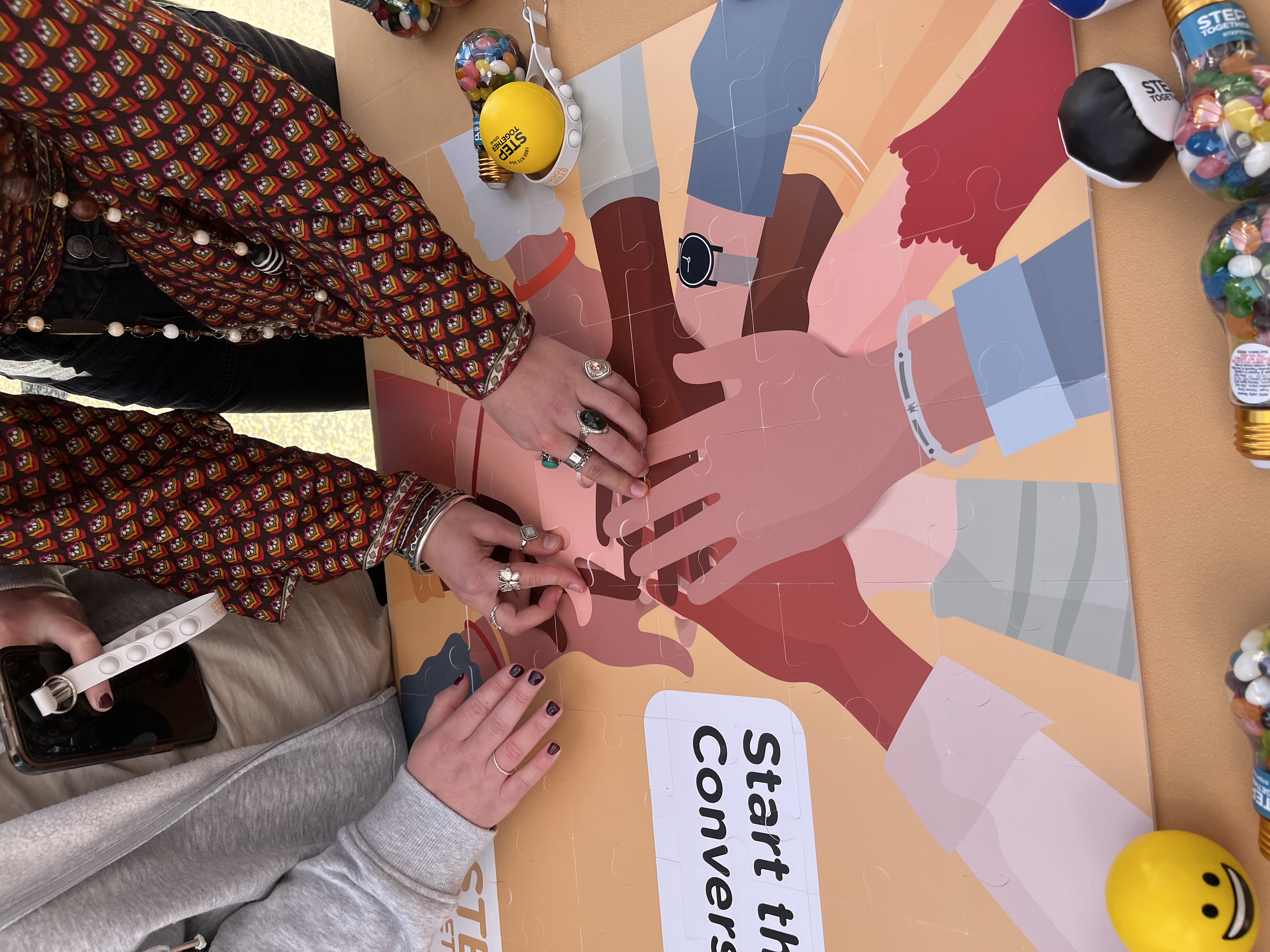 Image of hands completing a Step Together puzzle together.